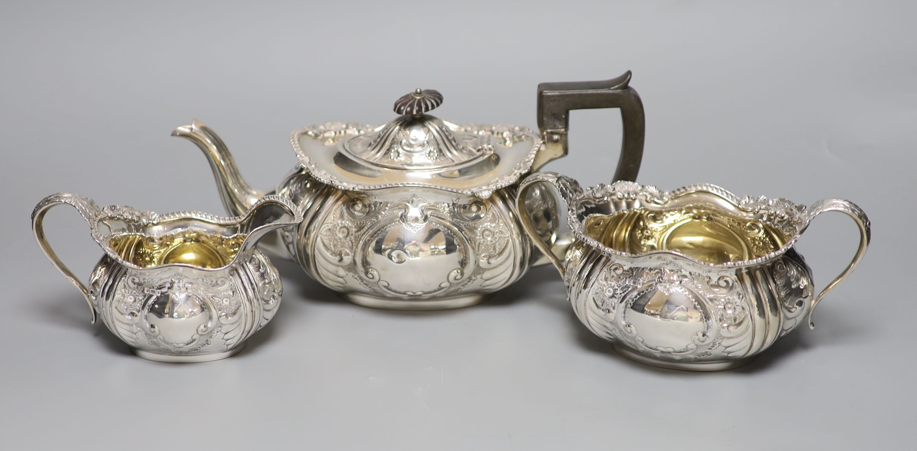 An Edwardian embossed silver three piece tea set, Hammond, Creake & Co, Sheffield, 1903